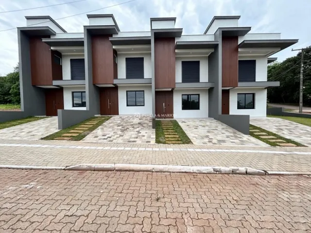 Fachada moderna de uma casa em Lajeado, Brasil, com revestimento em tons de marrom e cinza.