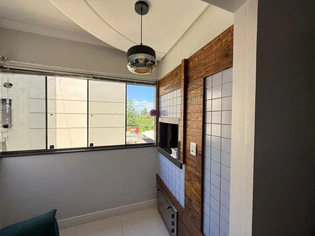 Foto de um corredor interno com parede de madeira e janela grande.