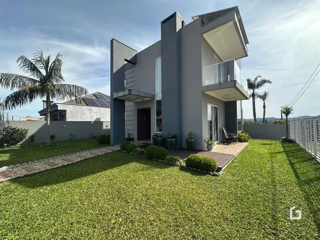 Fachada de uma casa moderna em Lajeado, Brasil, com jardim gramado.