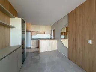Imagem de uma área de estar e cozinha em um apartamento moderno.