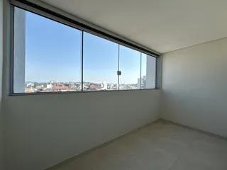 A sala possui uma grande janela com vista para a paisagem urbana.