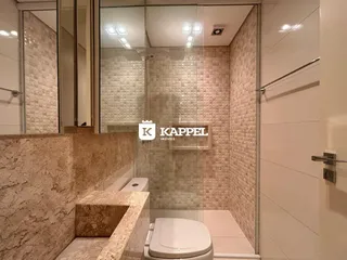 Banheiro com revestimento de azulejos e bancada de mármore.