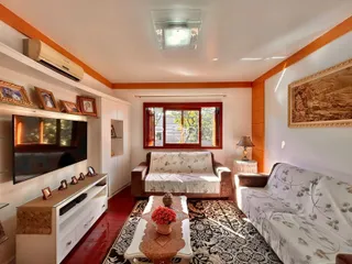 Sala de estar com sofá e televisão em um apartamento no Brasil.