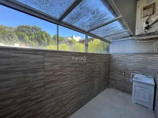 Interior de um cômodo com revestimento de madeira e piso claro.