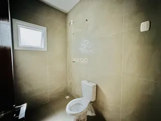 Foto de um banheiro com revestimento de cerâmica e janela.