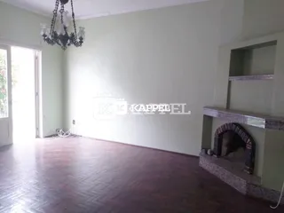Sala de estar com piso de madeira e lustre pendente.