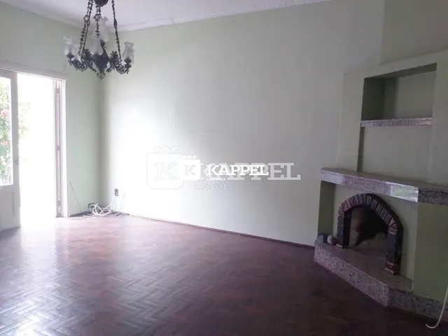 Sala de estar com piso de madeira e lustre pendente.