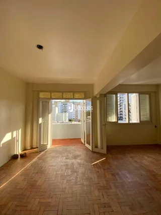 Corredor interno com piso de tijolo avermelhado e portas de madeira.