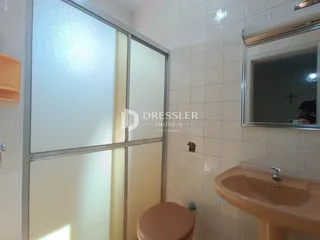 Foto de um banheiro com revestimento de azulejos brancos e pia de cor terracota.