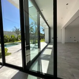 Sala de estar com grandes janelas de vidro que dão vista para o exterior.