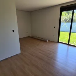Ambiente interno com piso de madeira e paredes brancas.