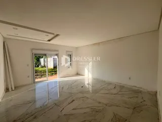Sala ampla com piso de mármore polido e portas de vidro.