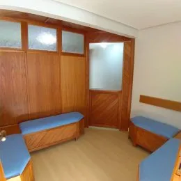 Ambiente interno com painéis de madeira escura na sala.