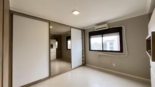 Hall de entrada com piso claro e janela de vista urbana.