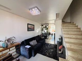 Sala de estar com sofá e escadaria em ambiente interno.