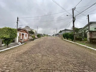 Vista da rua pavimentada em Lajeado, Brasil, com casas ao longo da via.
