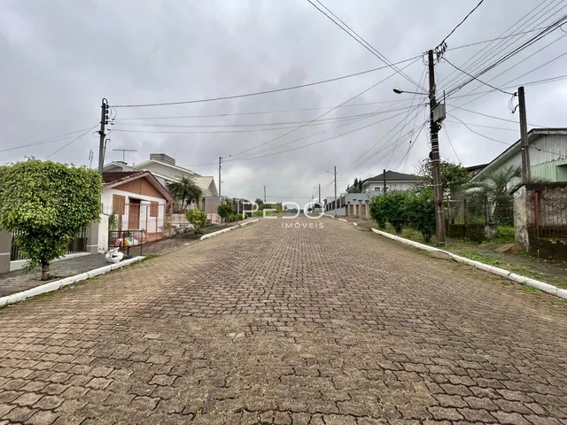 Vista da rua pavimentada em Lajeado, Brasil, com casas ao longo da via.