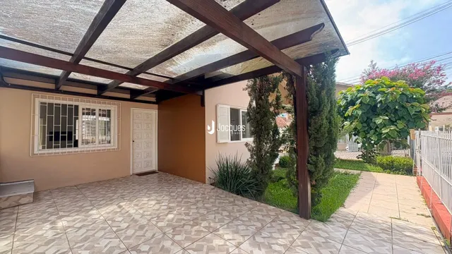 Vista externa de uma área coberta com piso de cerâmica e estrutura de madeira.