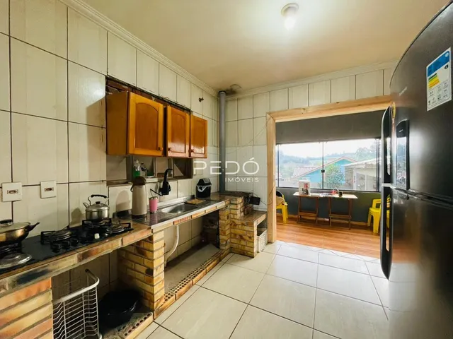 Vista da cozinha com armários de madeira e revestimento de cerâmica.
