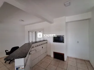 Cozinha com bancada de granito e piso de cerâmica, com janela e lareira.