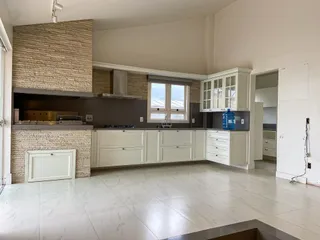 Cozinha com armários brancos e piso de porcelanato claro.