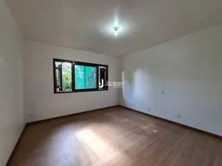 Ambiente interno com piso de madeira e paredes brancas.