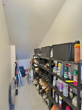 Hall de entrada com estantes de armazenamento e produtos ao longo da parede.