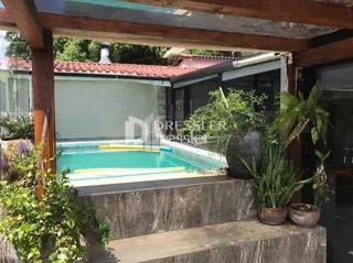 Foto de uma área externa com piscina e estrutura de madeira.