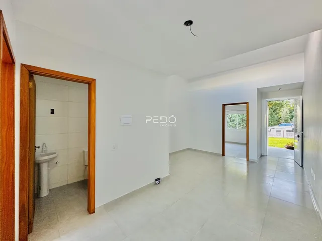 Interior de um corredor com portas de madeira e piso claro.