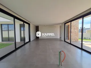 Vista ampla de um ambiente interno com piso de porcelanato e grandes portas de vidro.