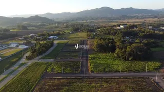 Vista aérea de uma propriedade rural com campos e vegetação ao redor.