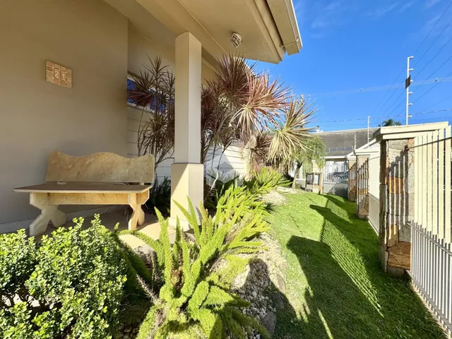 Fachada de uma residência com jardim e vegetação na Lajeado, Brasil.