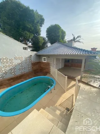 Foto da área externa mostrando uma piscina e um pátio.