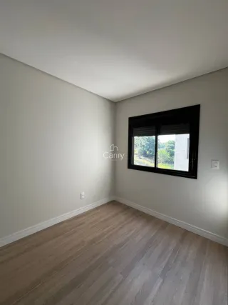 Foto de um cômodo interno com piso de madeira e uma grande janela.
