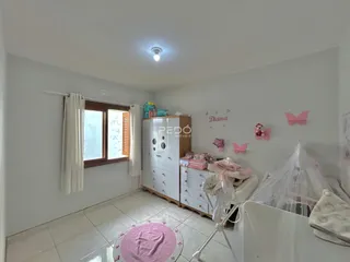 Quarto interno com armário branco e decoração rosa.