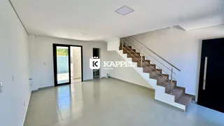 Ambiente interno amplo com piso claro e escadaria moderna.