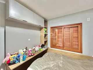Quarto com cama e armário de madeira em um imóvel no Brasil.