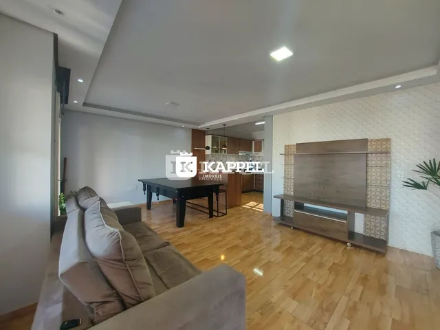 Sala de estar com sofá e piso de madeira clara.
