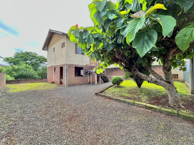 Vista externa de uma residência com fachada de tijolos e jardim em Lajeado.