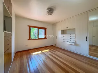 Sala de estar com piso de madeira e armários embutidos.