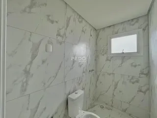 Foto de um banheiro com revestimento de azulejos brancos.