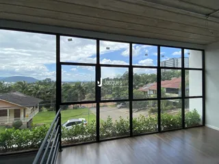 Vista da sala de estar com grandes janelas que dão para o exterior.