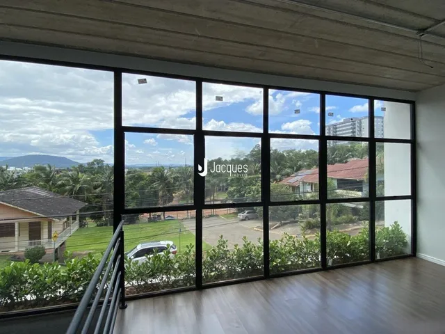 Vista da sala de estar com grandes janelas que dão para o exterior.