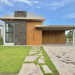 Fachada moderna de uma residência com paisagismo verde.