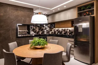 Foto de uma sala de jantar com mesa de madeira e cozinha moderna em um apartamento.