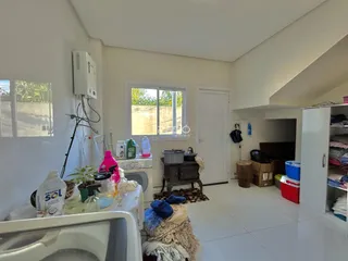 Interior de uma sala de estar com janela e parede branca.