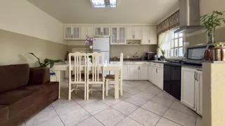 Foto de uma sala de jantar com armários brancos e mesa de madeira.