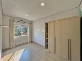 Sala de estar com piso de madeira e armário embutido.