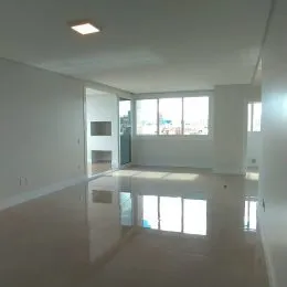 Ambiente interno amplo com piso brilhante e paredes brancas.