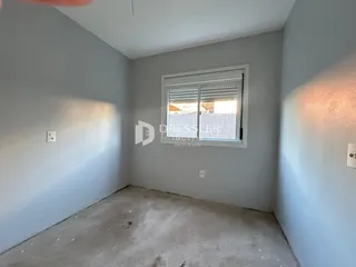 Foto de um cômodo vazio com paredes cinzas e piso de concreto.